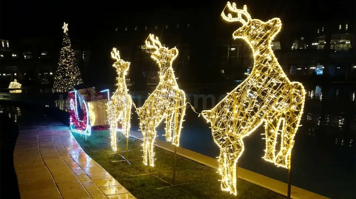 Su kenari acik alanda uc adet altin rengi LED geyik figuru ve yilbasi kizagi ile cam agaci