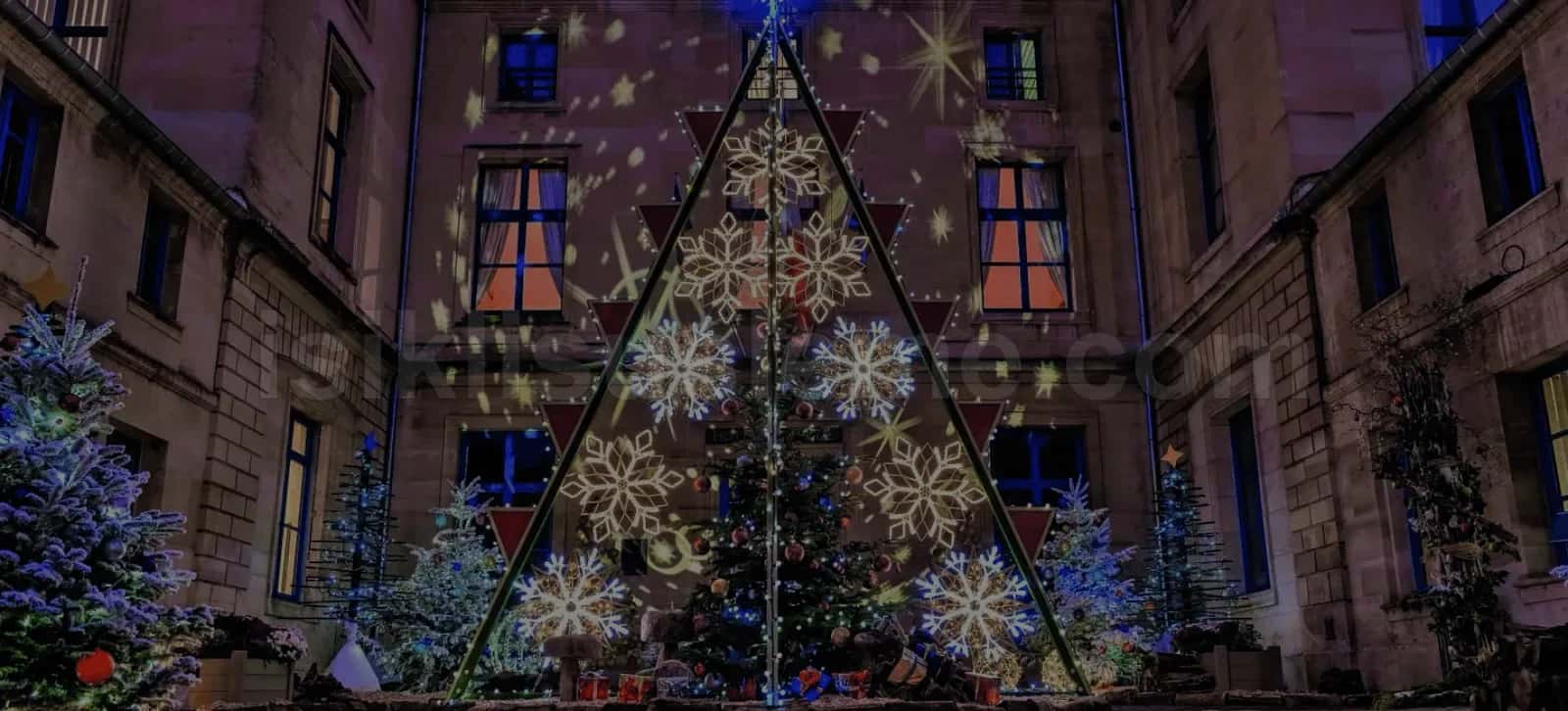 Tarihi bina ic avlusunda kar tanesi LED motifli yilbasi agaci gece gorunumu