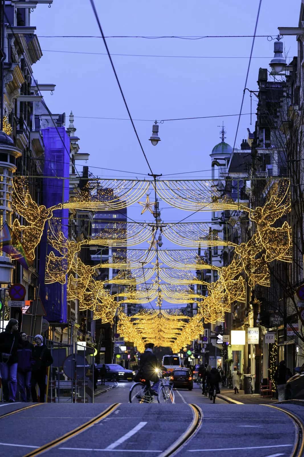 Genis sehir caddesinde altin sari melek figur LED motiflerinin cadde boyunca dizilimi