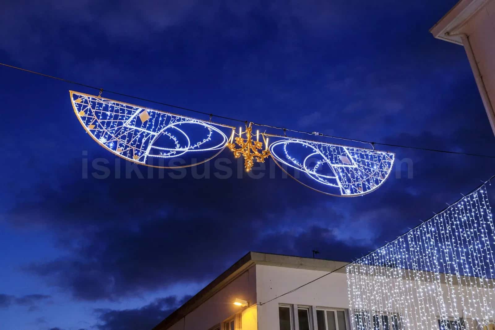 Geceleri cadde uzerine asili buyuk kanat seklinde mavi beyaz LED motif ve binada LED perde isik