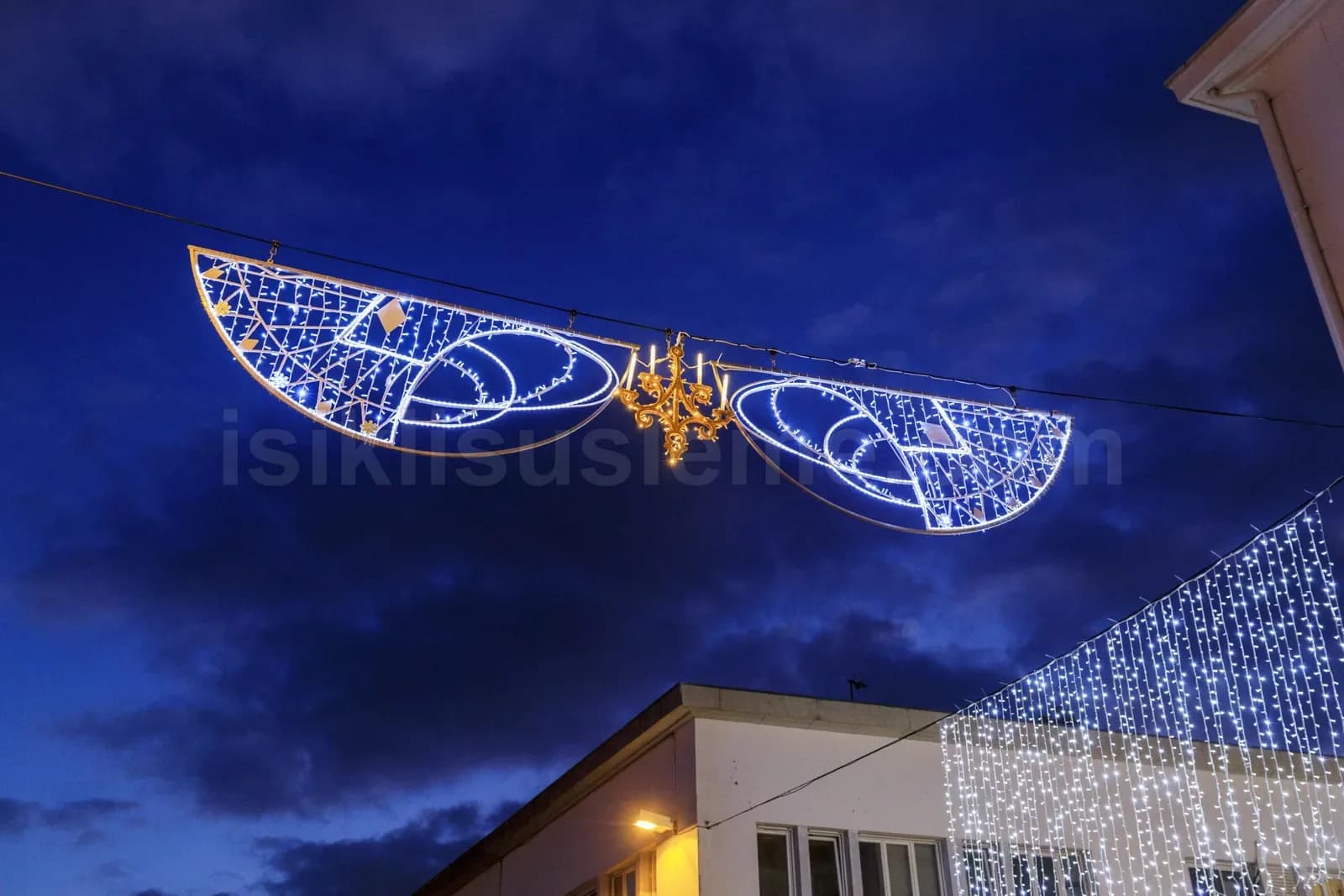 Geceleri cadde uzerine asili buyuk kanat seklinde mavi beyaz LED motif ve binada LED perde isik