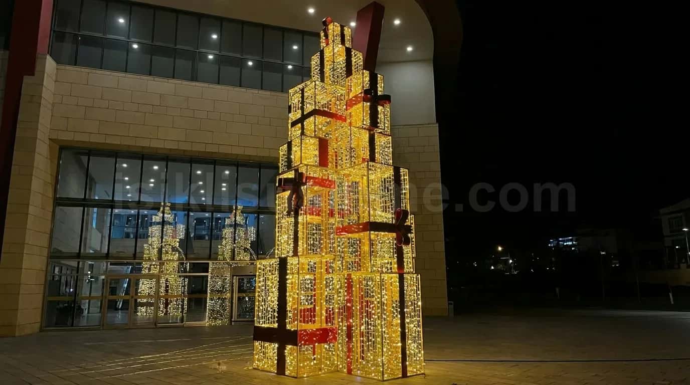 Bina onunde gece kurulu altin LED isikli dev istifli hediye kutusu kulesi