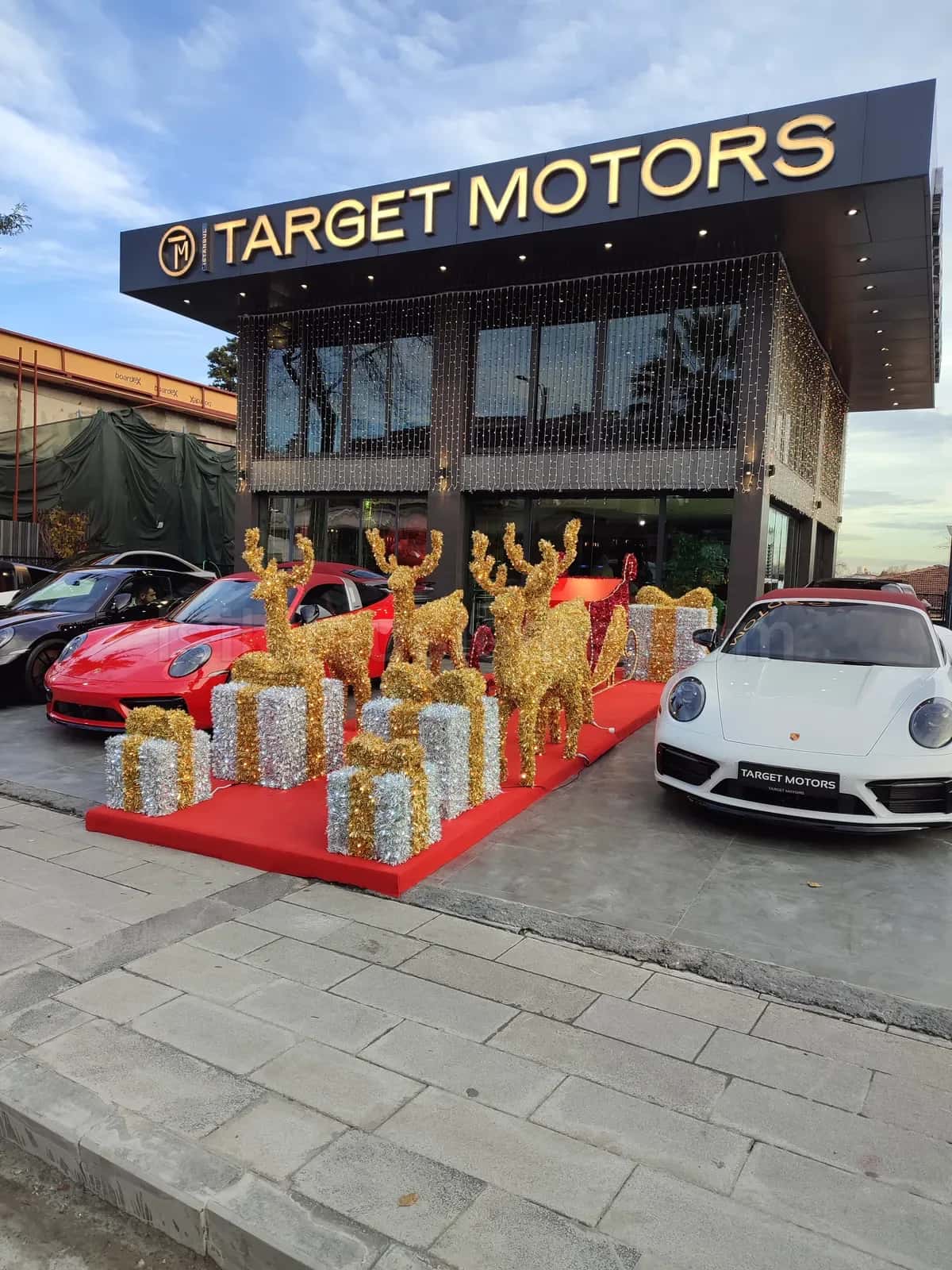 Otomotiv galerisi onunde altin rengi geyik kizak ve gumus hediye kutusu LED figur duzenleme