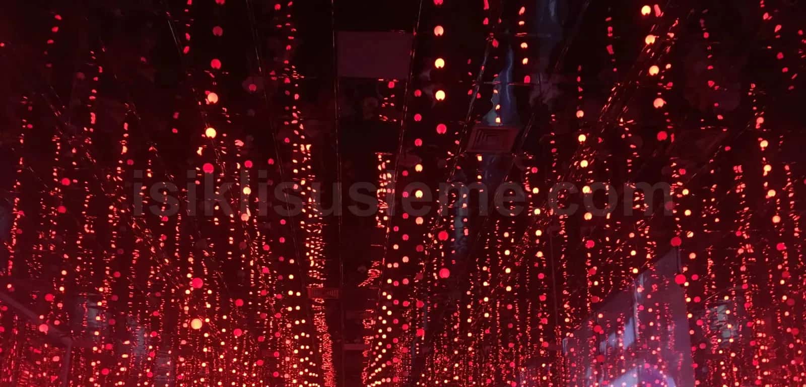 Sokak tavanından sarkan yüzlerce kırmızı LED top dizisi gece atmosferinde caddeyi kaplıyor