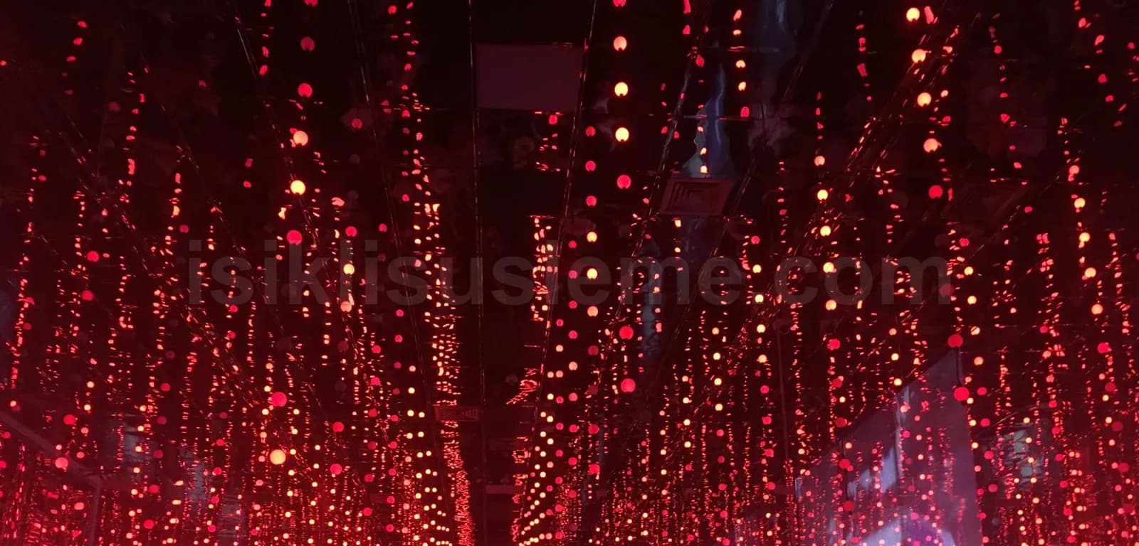 Sokak tavanından sarkan yüzlerce kırmızı LED top dizisi gece atmosferinde caddeyi kaplıyor