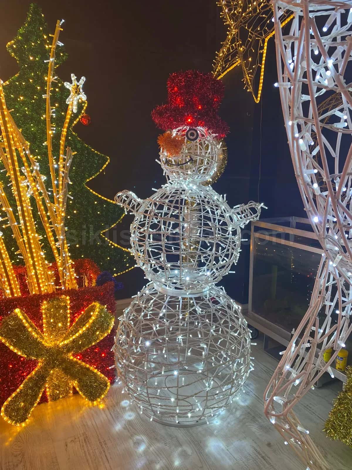 Kirmizi sapkali beyaz LED kardan adam figuru etrafinda farkli yilbasi LED figur ve susleme ornekleri