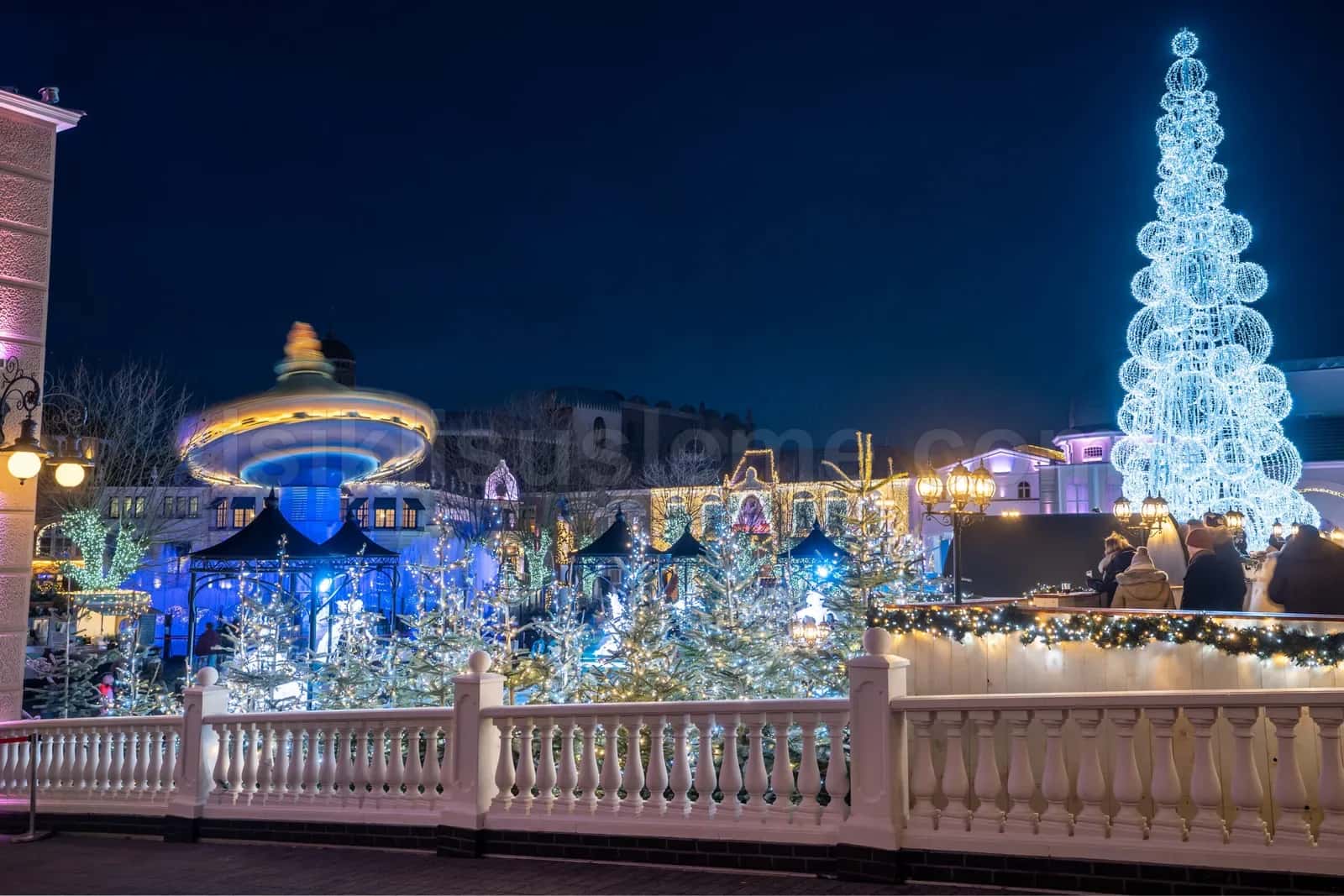 Acik alanda mavi ve beyaz LED ile suslenmis dev spiral yilbasi agaci ve etraf LED susleme
