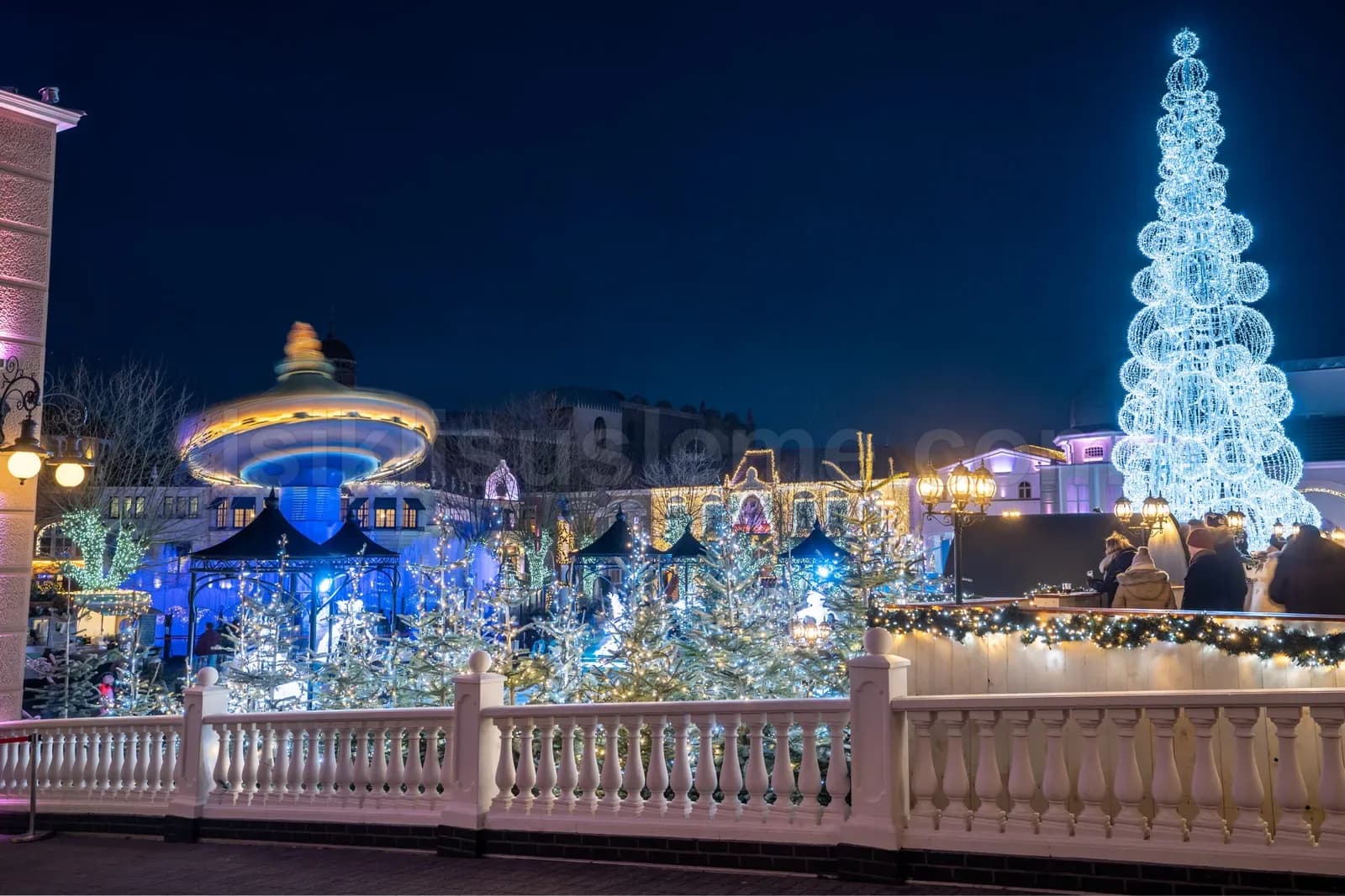 Acik alanda mavi ve beyaz LED ile suslenmis dev spiral yilbasi agaci ve etraf LED susleme