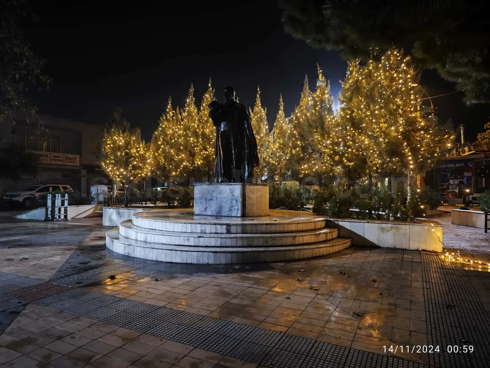 sehir meydaninda heykel etrafindaki agaclara sarili sicak beyaz led susleme yilbasi atmosferi gece