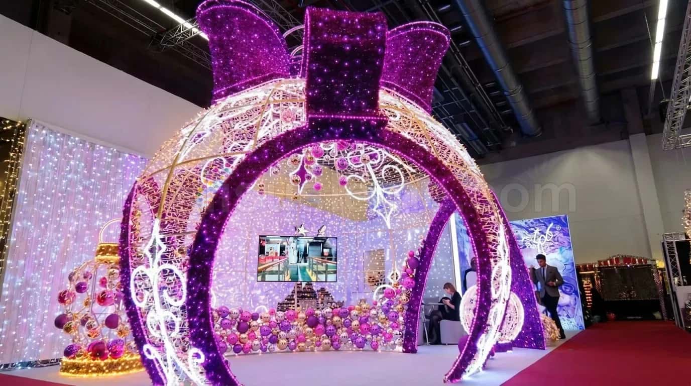 Fuar veya etkinlik alanında mor ve beyaz LED ışıklarla süslenmiş büyük yay kapı motifleri