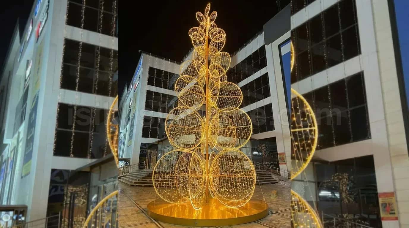 Plaza onunde altin sari LED isikli halka ve perde kombinasyonlu dev yilbasi cam agaci