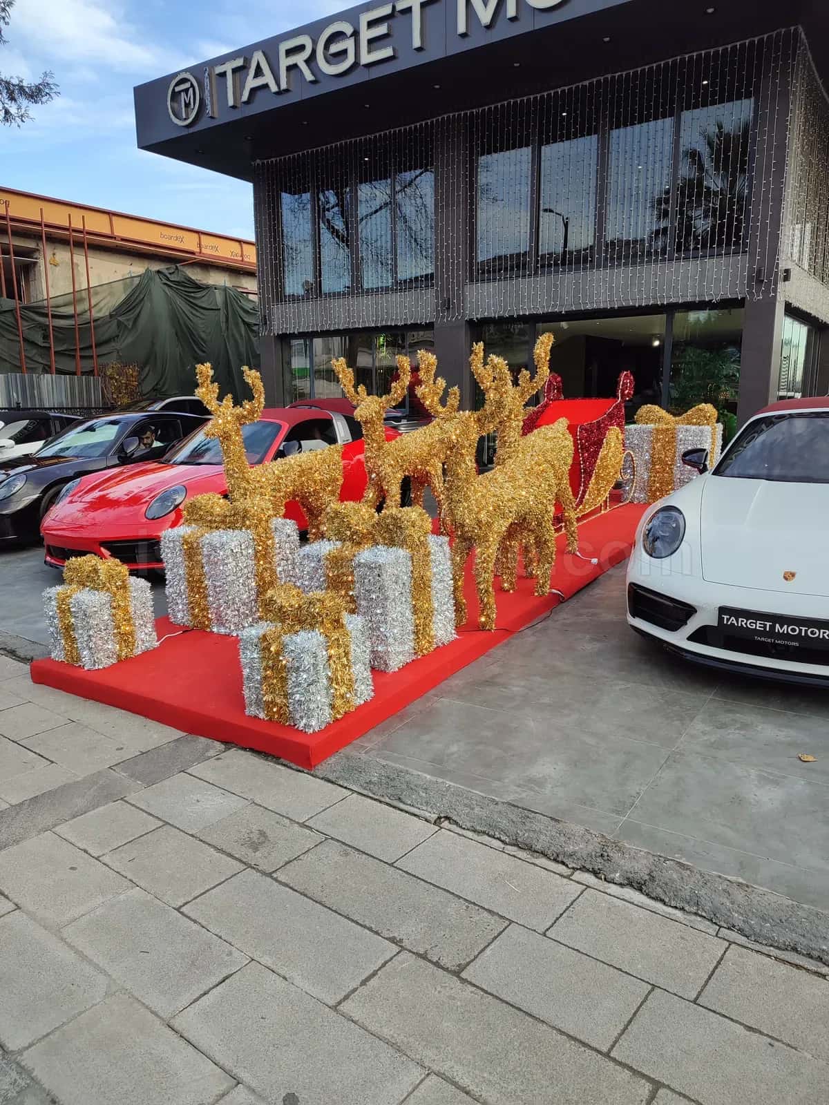 Target Motors showroom onunde altin geyik kizak LED figur kompozisyonu gunduz cekimi