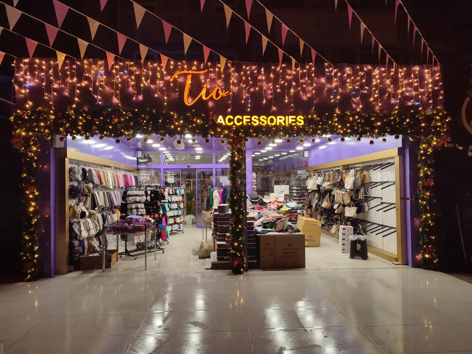 Tio Accessories aksesuar magazasinin girisinde sicak sari LED perde ve fistik susleme ile aydinlatilmis vitrin