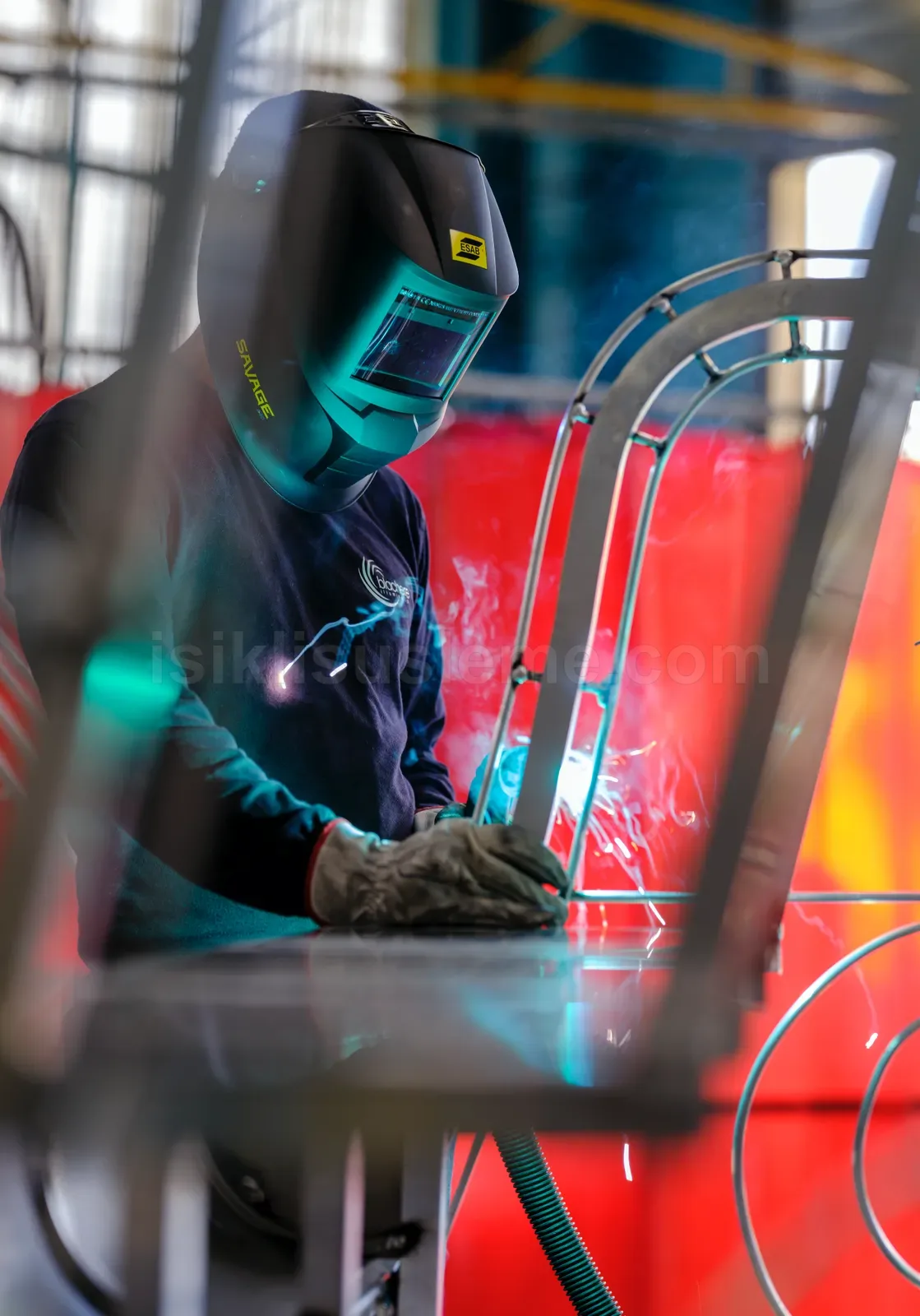 Atölyede koruyucu maskeyle LED figur metal iskeleti uzerine kaynak yapan iscinin yakin cekimi