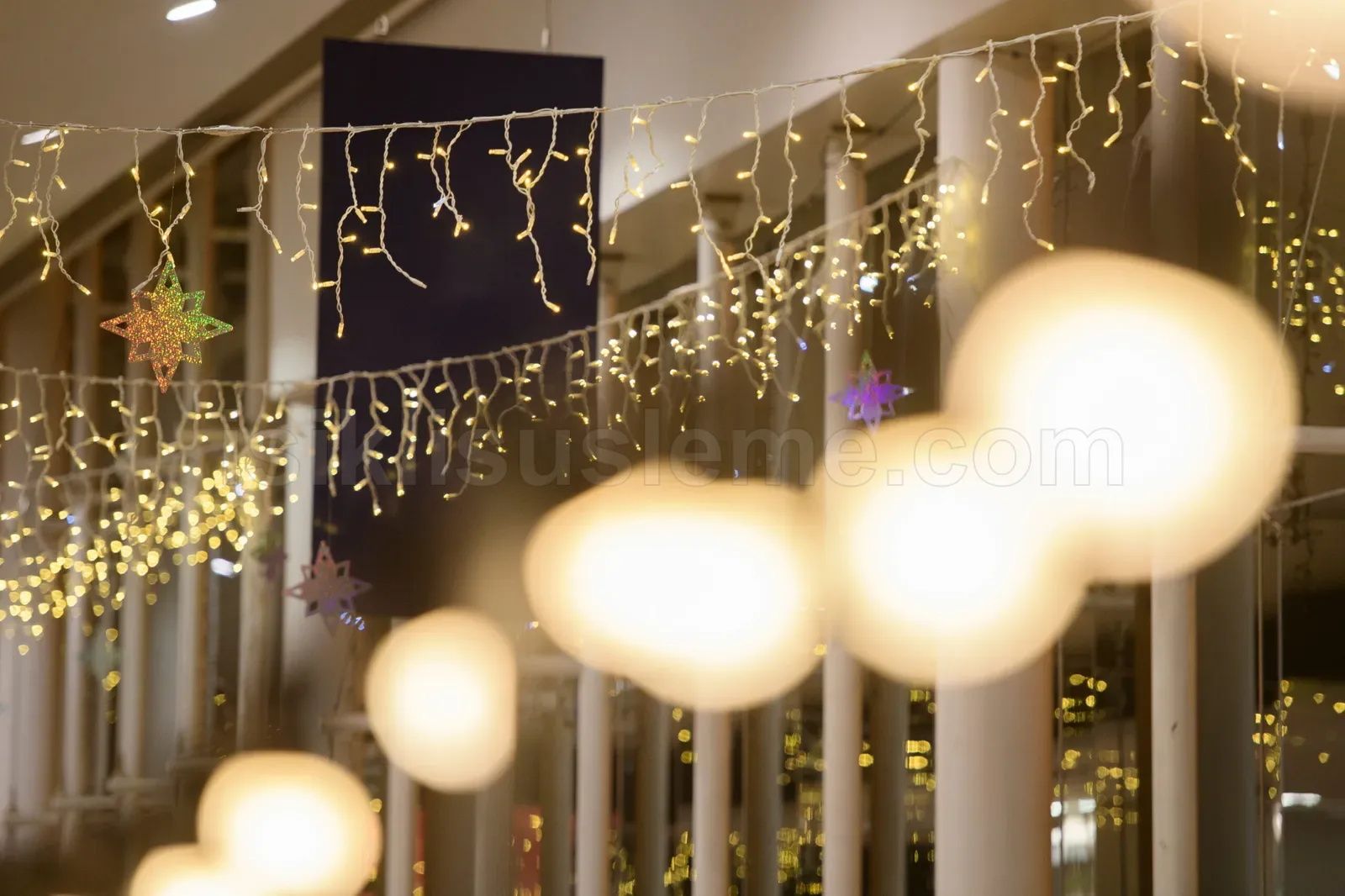 AVM ic mekaninda tavan sarkıt sarı LED isiklar ve buyuk kure ornamentler yakın plan
