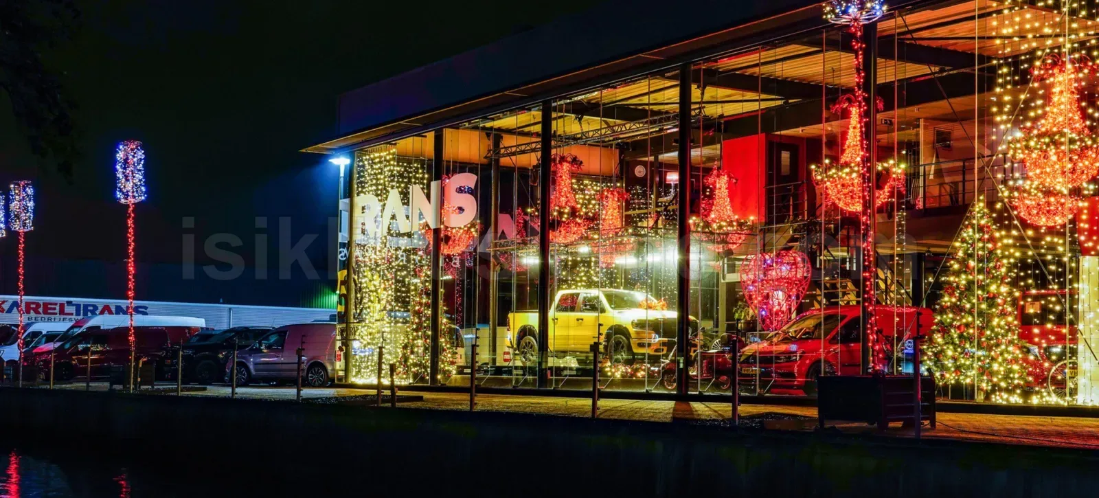 Gece cam cepheli oto galeride kirmizi LED agaclar ve renkli yilbasi susleme vitrin uygulamasi