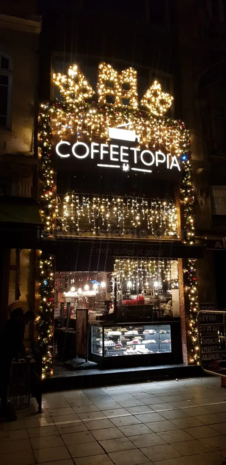 Coffeetopia kafesinin dis cephesi hediye paketi seklinde LED figur ve sarkit sicak beyaz LED suslemeyle donatilmis gece gorunumu