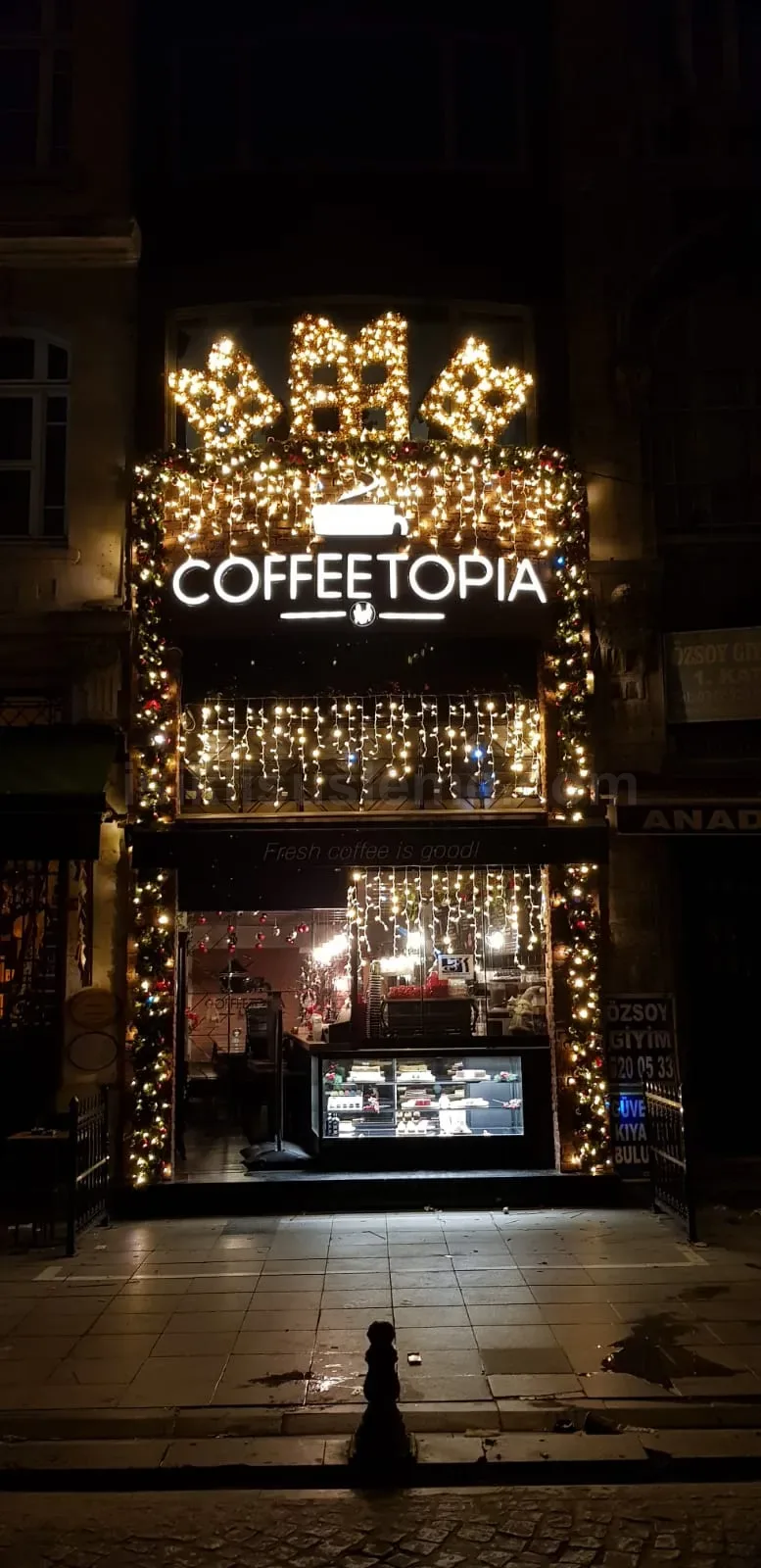 Coffeetopia kafe dis cephesi boydan boya sicak sari LED perde ve yilbasi suslemesiyle gece gorunumu