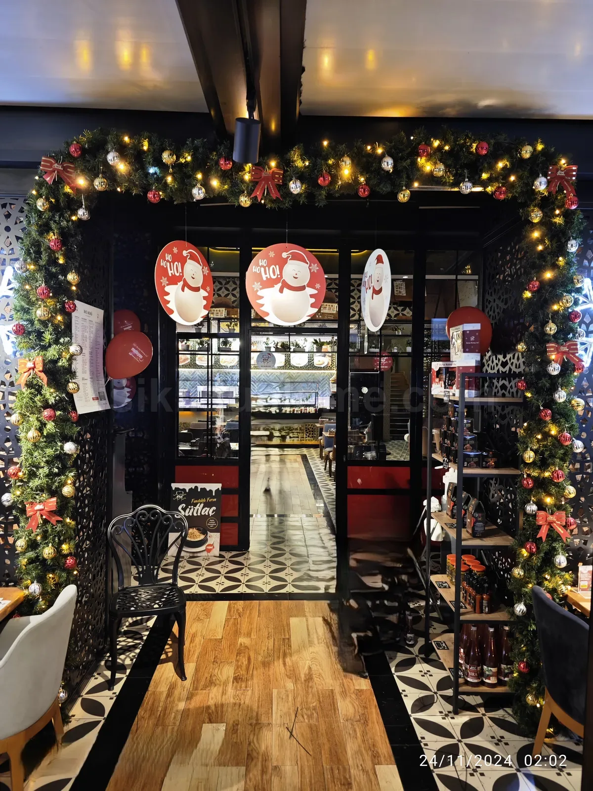 kafe ic mekaninda cam agaci led susleme ve noel baba figurleriyle suslu giris kapi kemeri