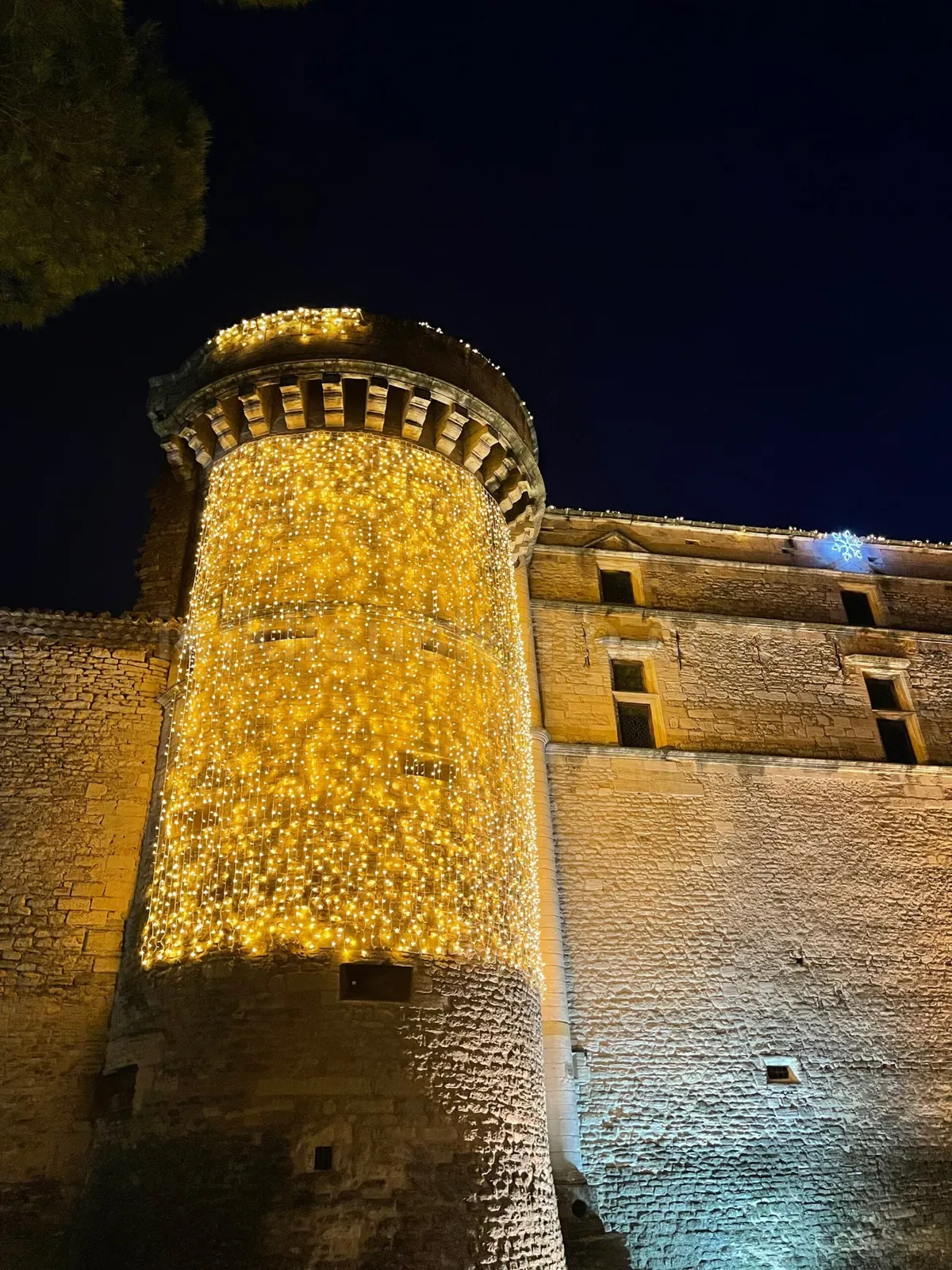Tarihi tas kale kulesini kaplayan yogun sari-altin LED zincir ortusu gece fotografi