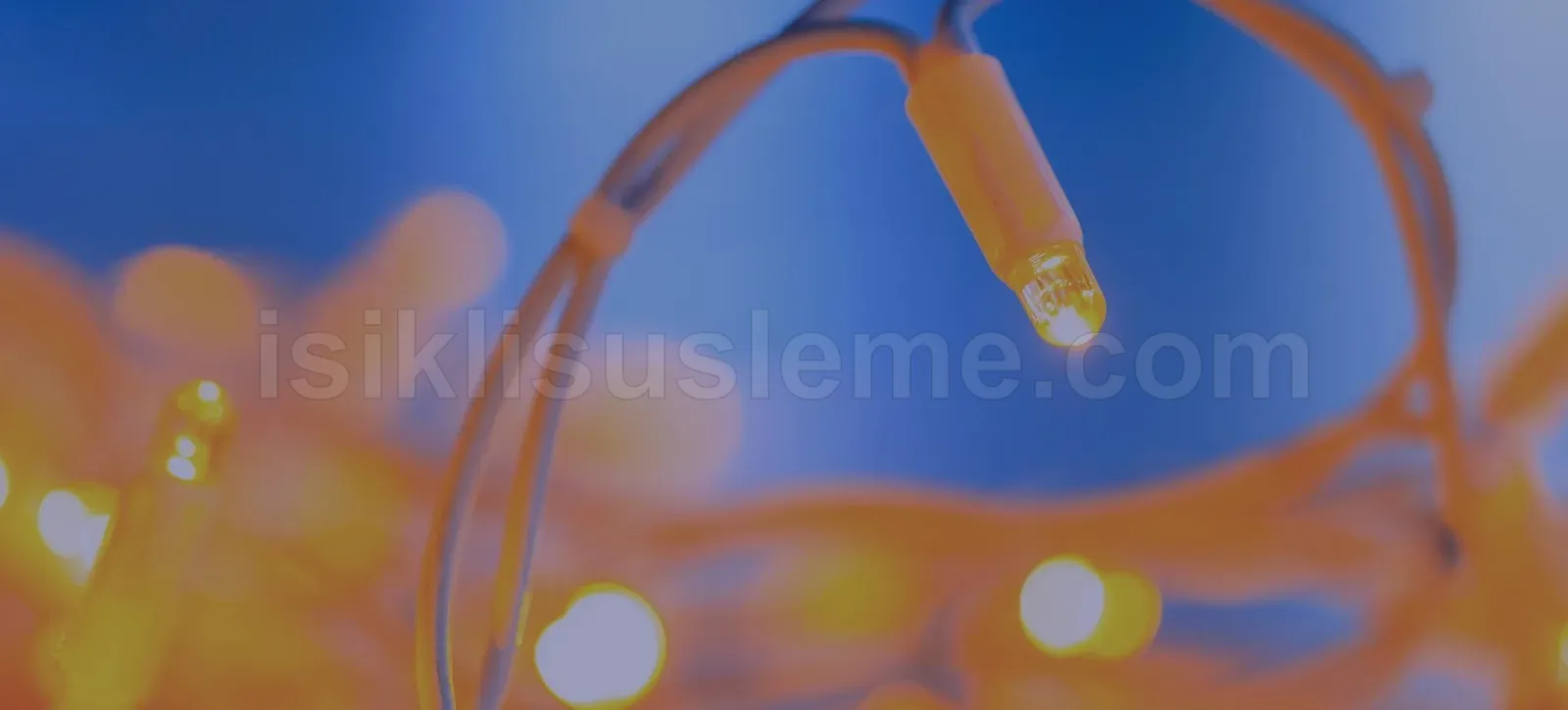 Mavi arka planda sıcak sarı LED ampullerin kablo detayını gösteren yakın çekim fotoğrafı