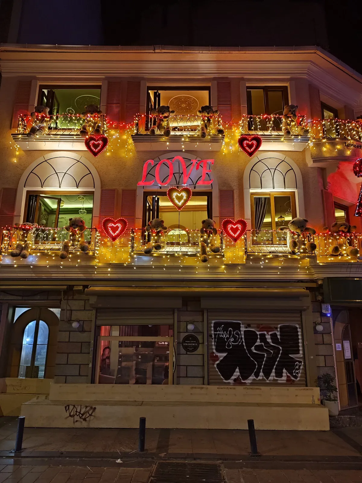 Gece iki katli restoran cephesinde kirmizi kalp LED figurler ve LOVE neon tabelasi