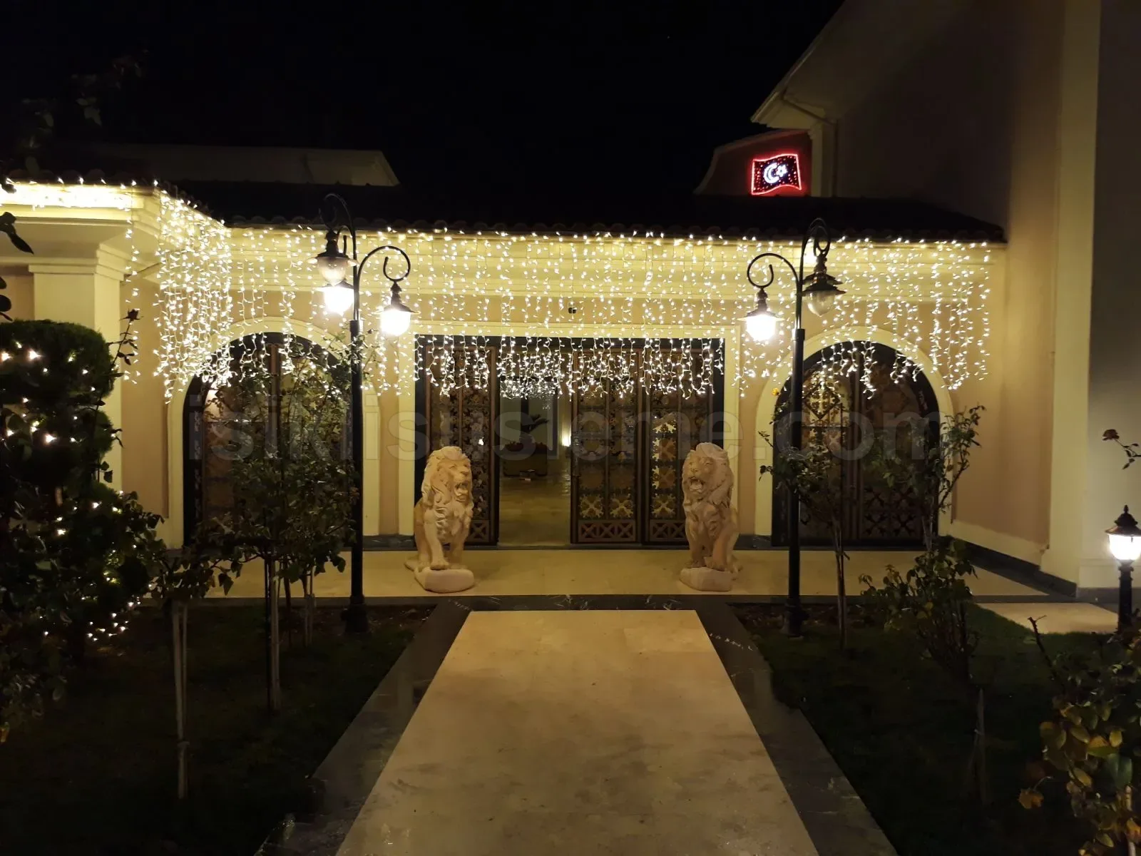 Aslan heykelli restoran girisinde sacak LED perde susleme beyaz ve sari renk geceleri