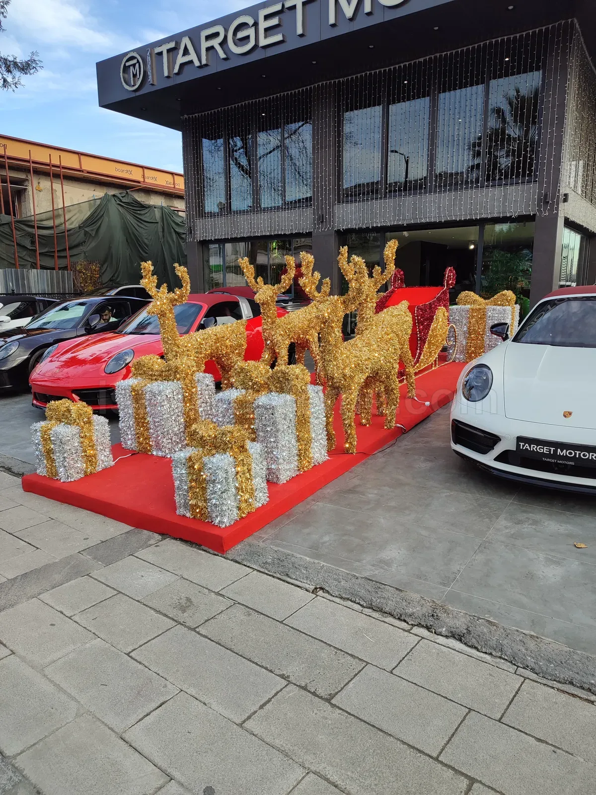 Target Motors showroom onunde altin geyik kizak LED figur kompozisyonu gunduz cekimi