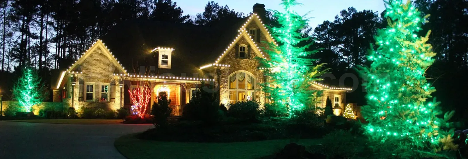 Gece villa cephe sacagina gerdirilen beyaz LED ve bahcede yesil kirmizi LED ile aydinlatilmis agaclar
