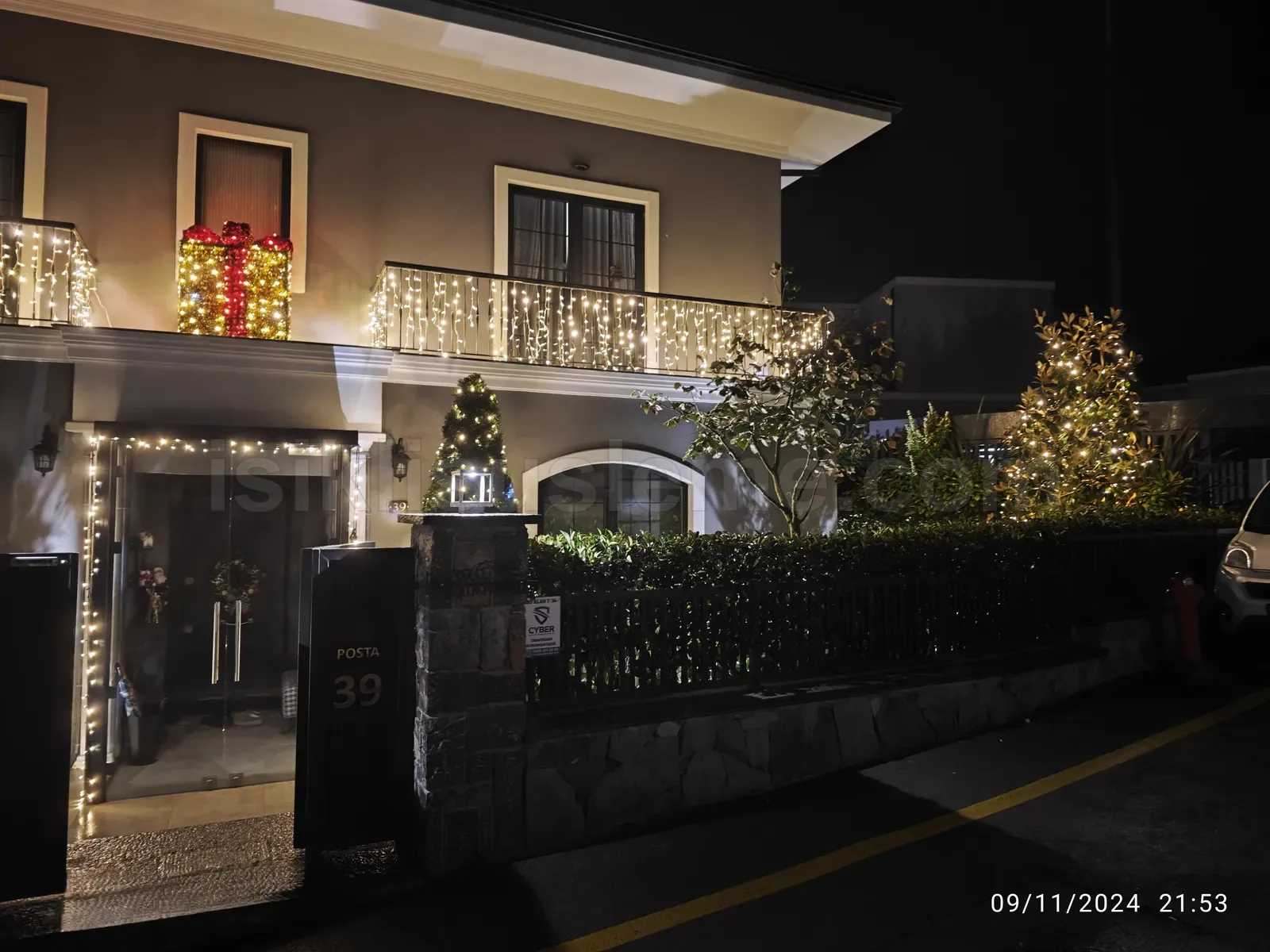iki katli villa cephesinde sicak beyaz perde led ve bahce agaci yilbasi isiklandirmasi gece cekimi