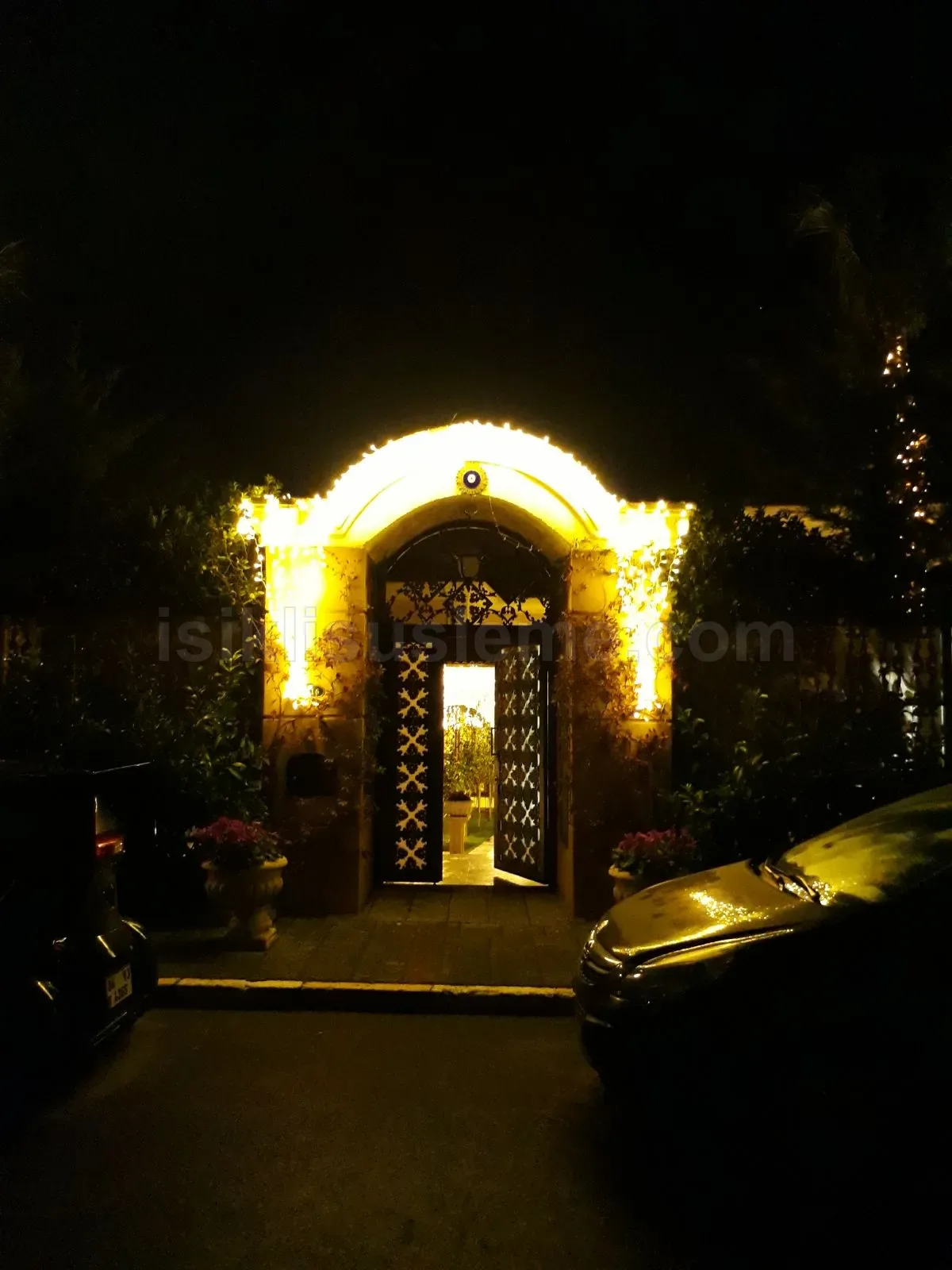 Gece cekimi villa giris kemeri etrafinda sicak sari LED peri isigi susleme