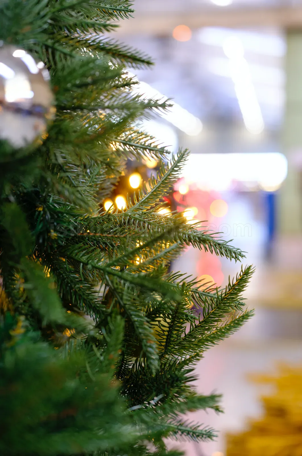 Atolye ortaminda hazirlanmakta olan yesil yapay cam agaci dallari ve arkada bokeh led isiklar
